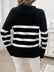 Dettaglio del maglione in maglia a righe bianche e nere con polsini a coste sul retro