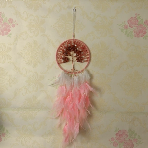 Macro detail of the tree of life dreamcatcher with pink quartz stones and soft feathers
