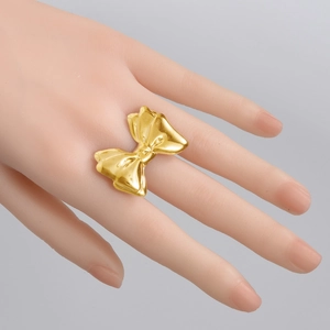 Polished gold butterfly bow ring in 304 stainless steel shown on a model hand
