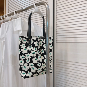 Detailed shot of floral canvas tote bag featuring reinforced leather handles and metal rivets