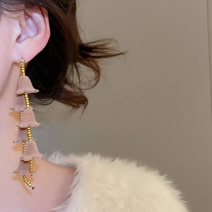 Gros plan de boucles d'oreilles pompons fleurs en velours rose au style rétro élégant