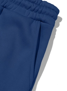 Detail of navy blue cargo sweatpants showing elastic waistband and side pocket texture