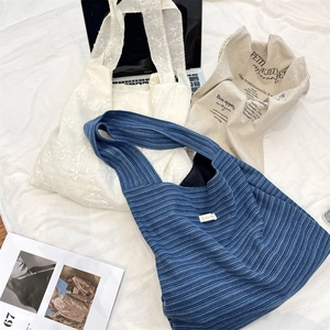 Detailed view of striped, floral, and vintage canvas tote bags with wide shoulder straps