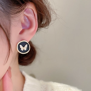 Vintage round black and gold butterfly stud earrings worn for an elegant French style