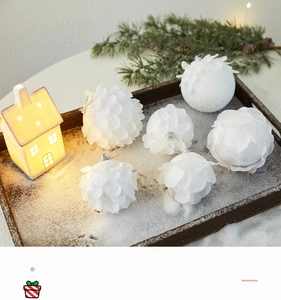Close-up of white foam petal Christmas balls in a rustic winter scene on a wooden tray