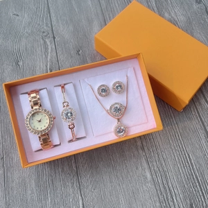 Close-up of rose gold watch and jewelry set with crystal accents in a luxury gift box