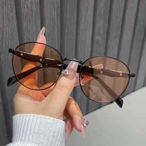 Detailed close-up of retro round metal sunglasses with brown lenses and black frame