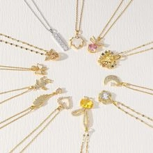 Macro shot of assorted heart, moon and butterfly gold pendants with zircons