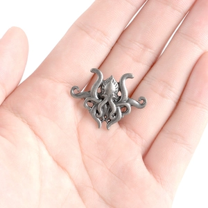 Vintage silver octopus brooch in Cthulhu style made of textured alloy on white background