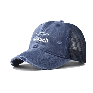 Detail of distressed navy denim trucker hat with gothic 'Blessed' embroidery and mesh back