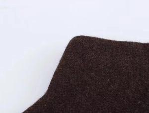 Vue macro détaillée du tissu en feutre marron foncé montrant la texture douce de la cape