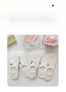 Close-up of white cotton low-cut socks with delicate floral embroidery for women