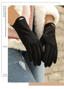 Detail of black faux suede gloves with small gold metal plate on the wrist cuff
