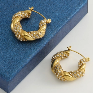 Macro view of 18k gold plated twisted hoop earrings with shimmering crystal accents