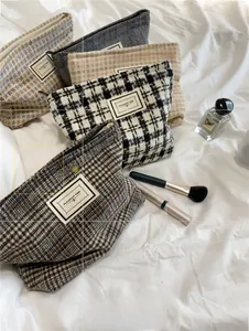 Detail view of plaid pattern cosmetic bag featuring retro Pleasant Time fabric patch