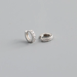 Macro shot of S925 sterling silver huggie earrings with shimmering cubic zirconia inlay