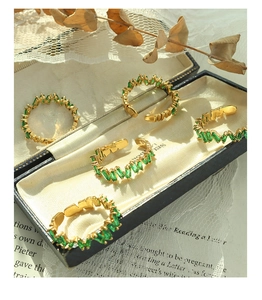 Macro view of vintage gold plated adjustable rings with emerald baguette cut stones
