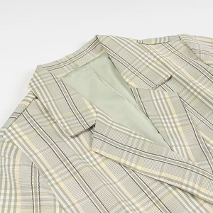 Close-up of green and white plaid blazer showing lapel collar and shoulder stitching details