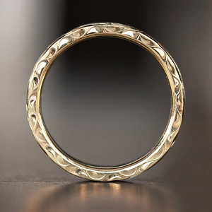 Detailed macro view of the vintage floral engraving on the side of a gold textured ring