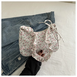 Detailed view of floral shoulder bag with pink tulip patterns and ruffled handle design