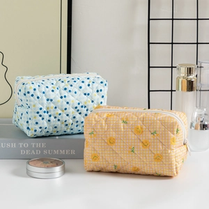 Detailed macro view of quilted cotton makeup bags with floral and polka dot patterns