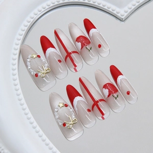 Christmas themed stiletto press-on nails with 3D bows, pearls and festive red accents