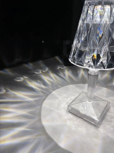 Detail of crystal table lamp showing radiant striped refraction shadows on a surface