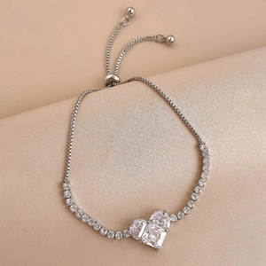 Elegant silver heart bracelet with sparkling cubic zirconia on luxury silk background