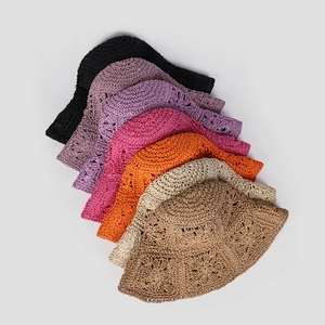 Close-up of multi-color crochet straw hats showing hollow wave patterns and texture