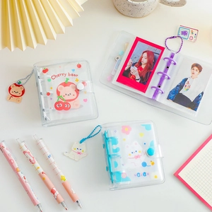Detailed view of clear PVC 3-hole mini photo albums with cute charms and matching pens