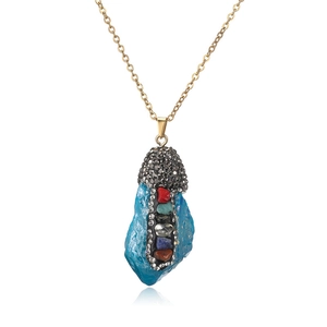 Macro detail of natural blue crystal pendant with multi-color stones on gold chain