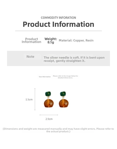 Detail view of 1.5cm by 2.9cm vintage earrings with green resin and amber spherical drop