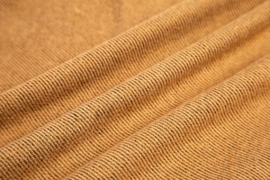Close-up of the brown and black twill fabric with wool blend texture and frayed edges