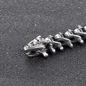 Detailed macro shot showing the dragon head and bone texture of the stainless steel bracelet