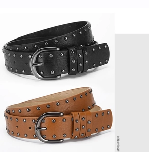 Detail view of black and brown vintage punk belts with double-row metal rivets and buckles