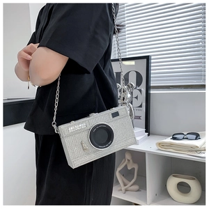 Close-up of a luxury silver rhinestone camera-shaped crossbody bag with a metal chain