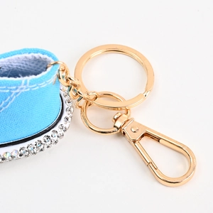 Detaillierte Makroansicht eines blauen Segelschuh-Schlüsselanhängers mit Strass und Goldring
