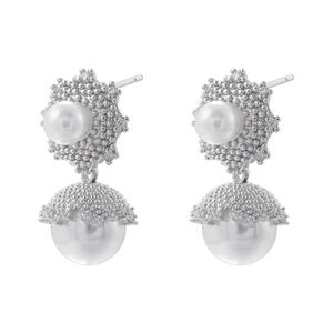 Detailed macro view of silver plated pearl earrings with micro-inlaid metallic caps