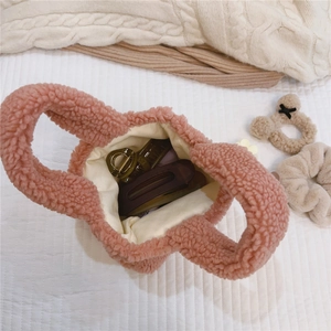 Intérieur du mini sac en peluche rose avec doublure beige et petites barrettes