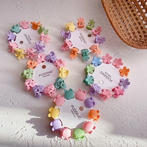 Set of mini candy-colored hair claws in crown and flower shapes on white card
