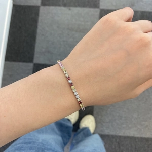 Wrist shot of a 925 sterling silver tennis bracelet with colorful round gemstones