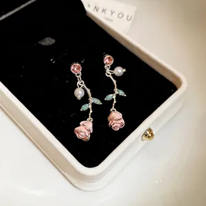 Pink enamel rose drop earrings with pearls and pink gemstones in a gift box jewelry display