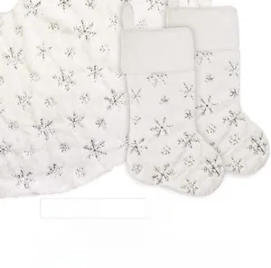 Detail of white plush Christmas stocking and tree skirt with silver sequin snowflakes