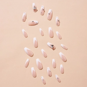 Classic French nude pink press-on nails with white tips and sparkling rhinestone accents