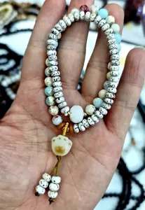 Detailed shot of star moon bodhi seed bracelet with light blue cat claw pendant