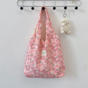 Detail of pink floral quilted fabric tote bag with soft texture and embossed pattern