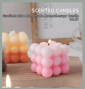 Macro shot of gradient cube scented candle on wooden tray with cozy background