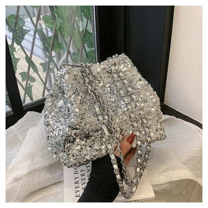 Close-up of shiny silver sequins and metal chain detail on the stylish bucket bag