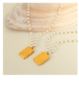 Vista macro della collana di perle con tulipano inciso e pendenti in oro con finitura a specchio