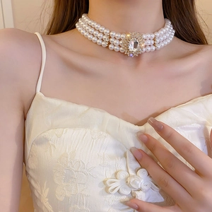 Détail d'un collier ras du cou vintage à perles multicouches avec pendentif